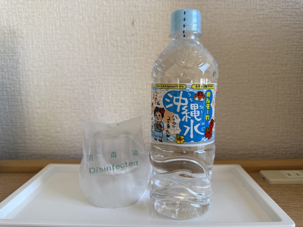 沖縄サンプラザホテルの客室に置かれたペットボトルの水とグラス