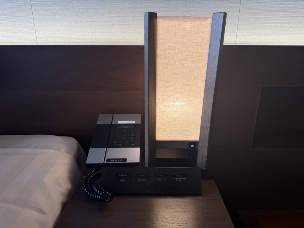 ベッド横の電話とライトとコンセント